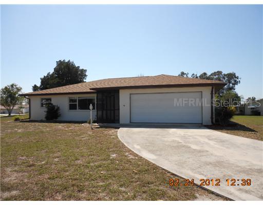 132 Caddy Road Rotonda West, FL 33947 - Photo 1 of 1 a front view of a house with a yard and garage