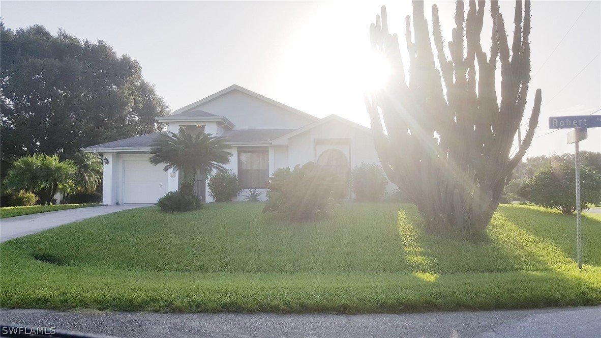 606 Robert Avenue Lehigh Acres, FL 33936 - Photo 1 of 14 a front view of a house with garden
