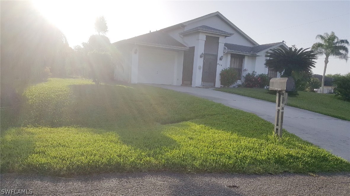 606 Robert Avenue Lehigh Acres, FL 33936 - Photo 4 of 14 a front view of a house with garden