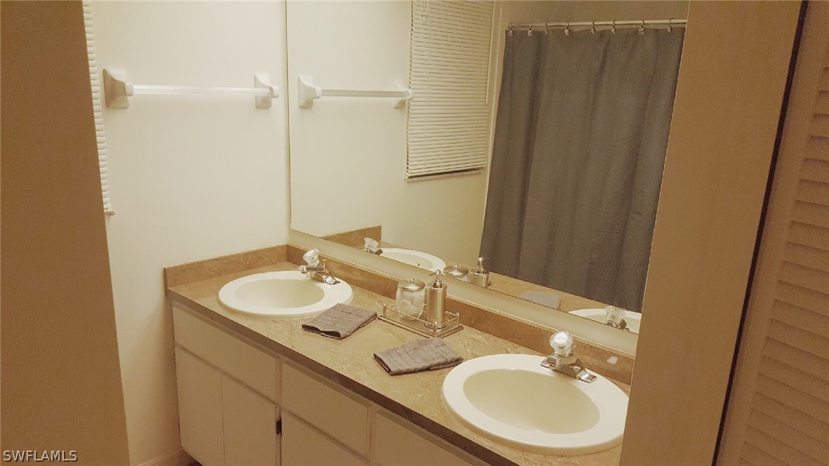 606 Robert Avenue Lehigh Acres, FL 33936 - Photo 10 of 14 a bathroom with a sink and a mirror