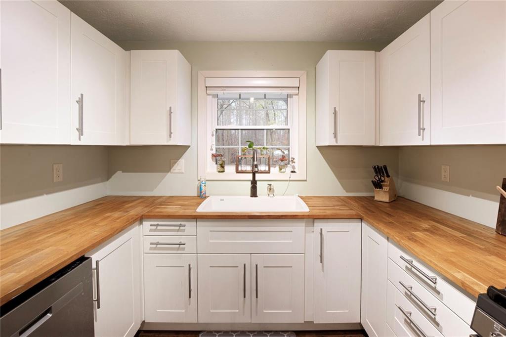310 Natchez Trace Atlanta, GA 30350 - Photo 21 of 55 a kitchen with granite countertop white cabinets and white appliances