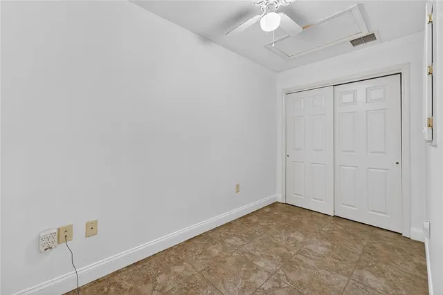an empty room with a ceiling fan and a window