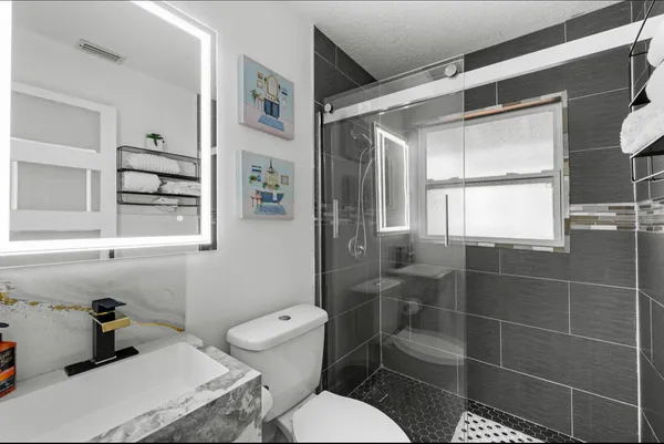 a bathroom with a toilet sink and shower