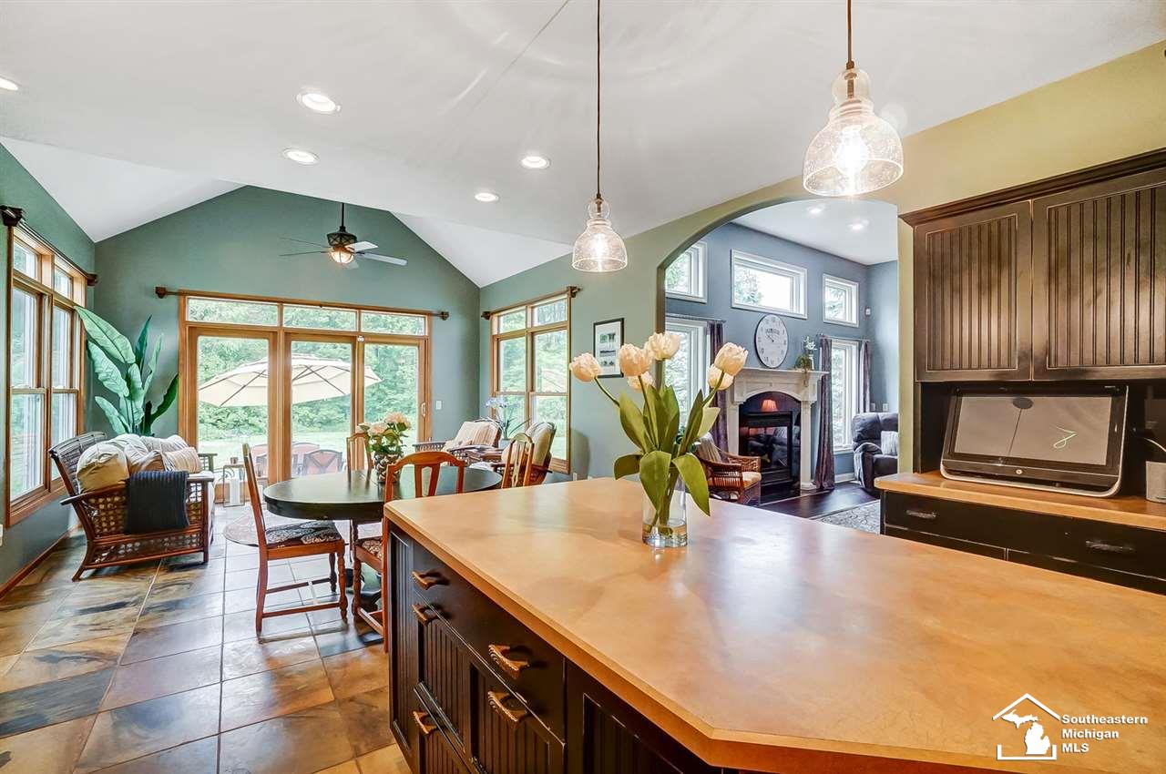 6475 Douglas Road Lambertville, MI 48144 - Photo 15 of 39 The kitchen extends into an amazing vaulted sun room with tons of natural light and surround views of private backyard; sliding glass door leads down to patio.