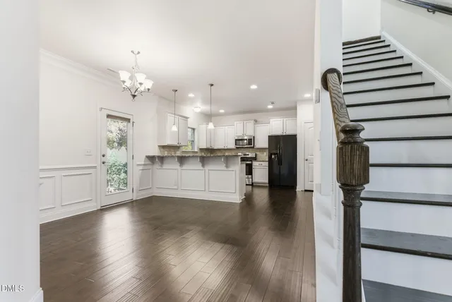 a kitchen with kitchen island granite countertop white cabinets a counter a sink and stainless steel appliances