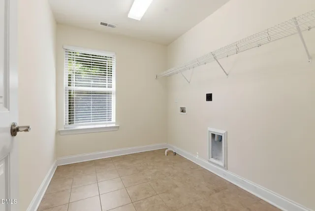 a bedroom with a bed a chandelier and a window