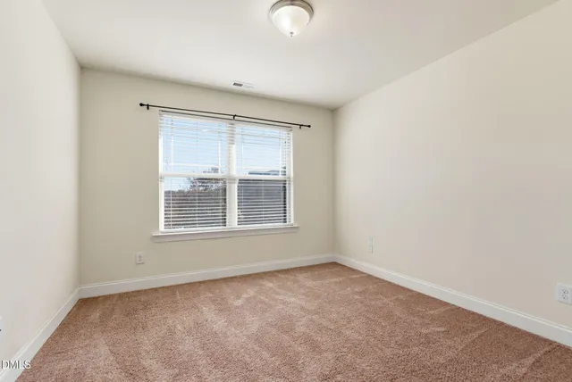an empty room with a ceiling fan and a window