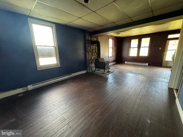 a view of a room with wooden floors and windows