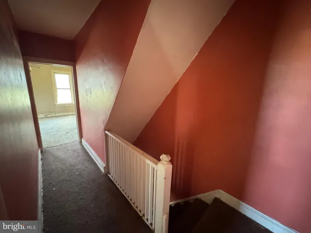 an empty room with chandelier fan and windows