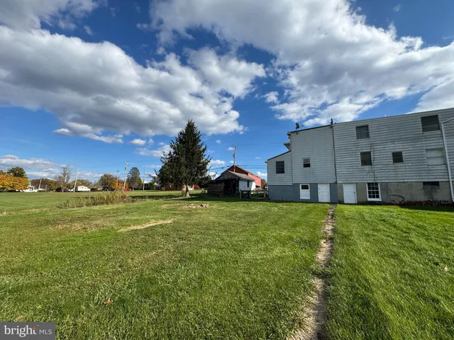 a view of a big house with a big yard and large trees