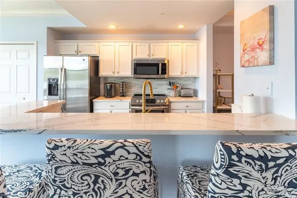 a kitchen with stainless steel appliances granite countertop a refrigerator and a stove top oven