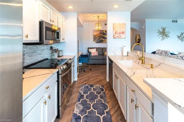 a kitchen with stainless steel appliances granite countertop a sink stove and cabinets