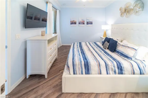 a bedroom with a bed and a flat screen tv