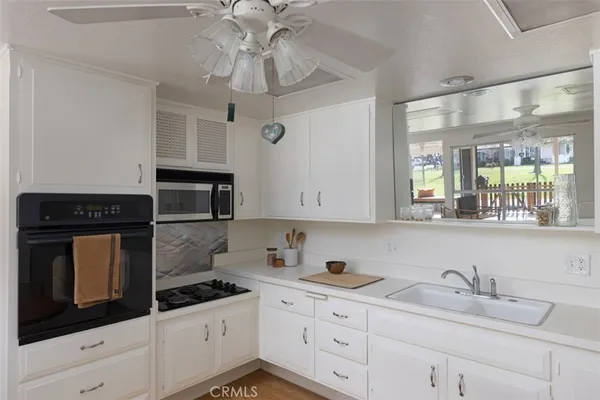 a kitchen with stainless steel appliances granite countertop a sink a stove and cabinets