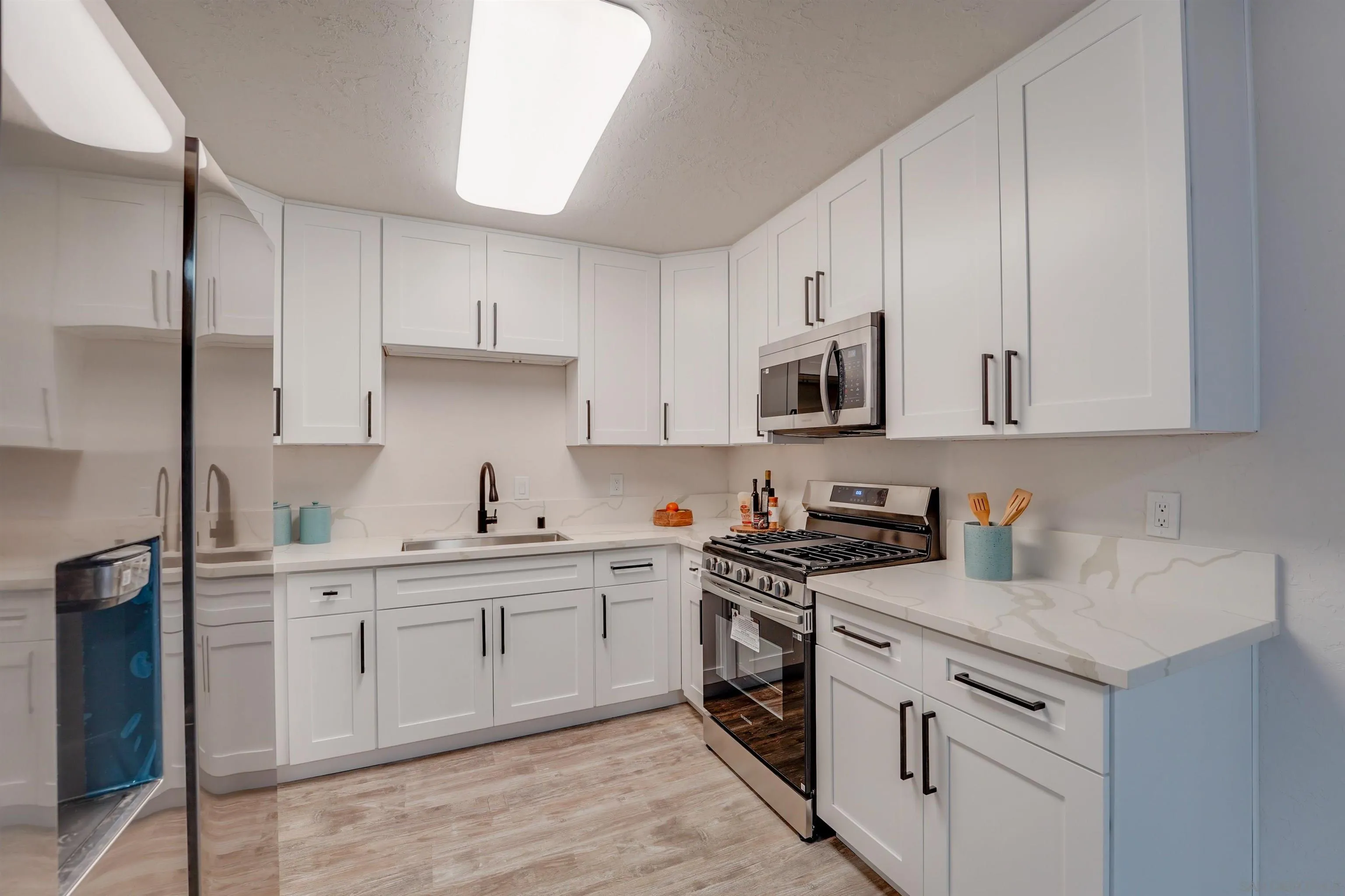 674 Palomar Avenue El Cajon, CA 92020 - Photo 24 of 56 a kitchen with stainless steel appliances granite countertop white cabinets a sink a stove a refrigerator and white cabinets