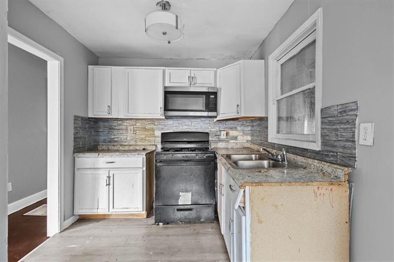 685 Bolton Road Northwest Atlanta, GA 30331 - Photo 5 of 21 a kitchen with stainless steel appliances granite countertop a stove sink and microwave
