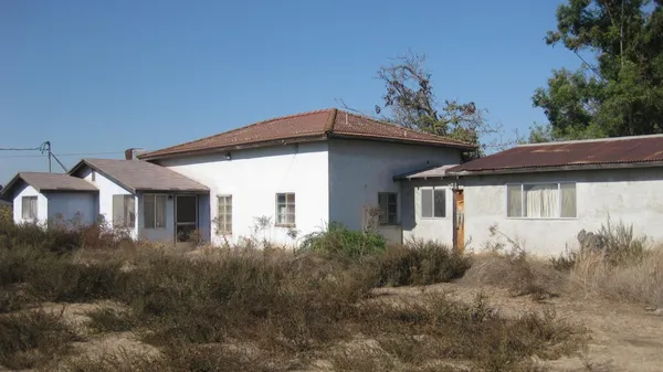 a front view of house with yard and trees around