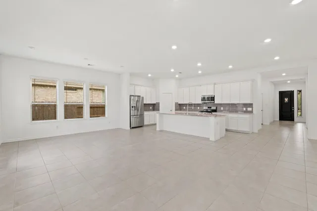 a large kitchen with stainless steel appliances granite countertop a stove a sink and a microwave