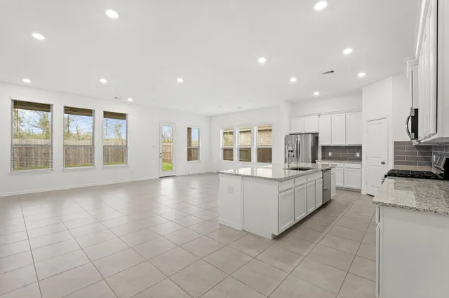 a view of kitchen with kitchen island and stainless steel appliances