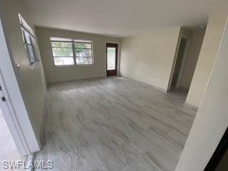 27677 Okeana Street, Unit 6 Bonita Springs, FL 34134 - Photo 17 of 31 a view of an empty room with a window and wooden floor