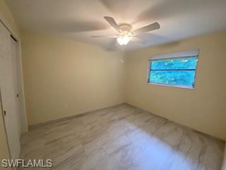 27677 Okeana Street, Unit 6 Bonita Springs, FL 34134 - Photo 20 of 31 an empty room with a chandelier fan and windows
