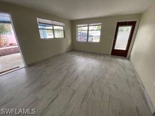 27677 Okeana Street, Unit 6 Bonita Springs, FL 34134 - Photo 8 of 31 an empty room with wooden floor and windows
