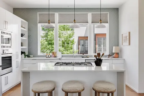 a kitchen with a stove a sink and a window