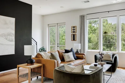 a living room with furniture and floor to ceiling windows