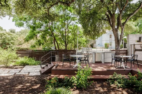 a view of a patio with table and chairs and a large tree