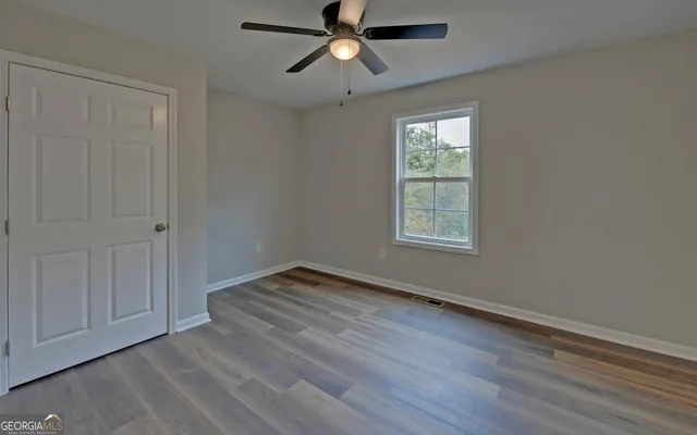 a view of empty room with wooden floor