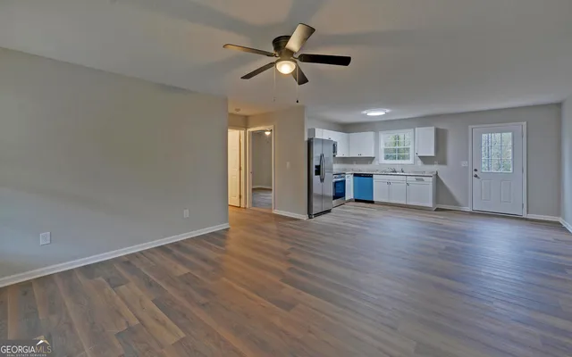 a view of an empty room with a kitchen