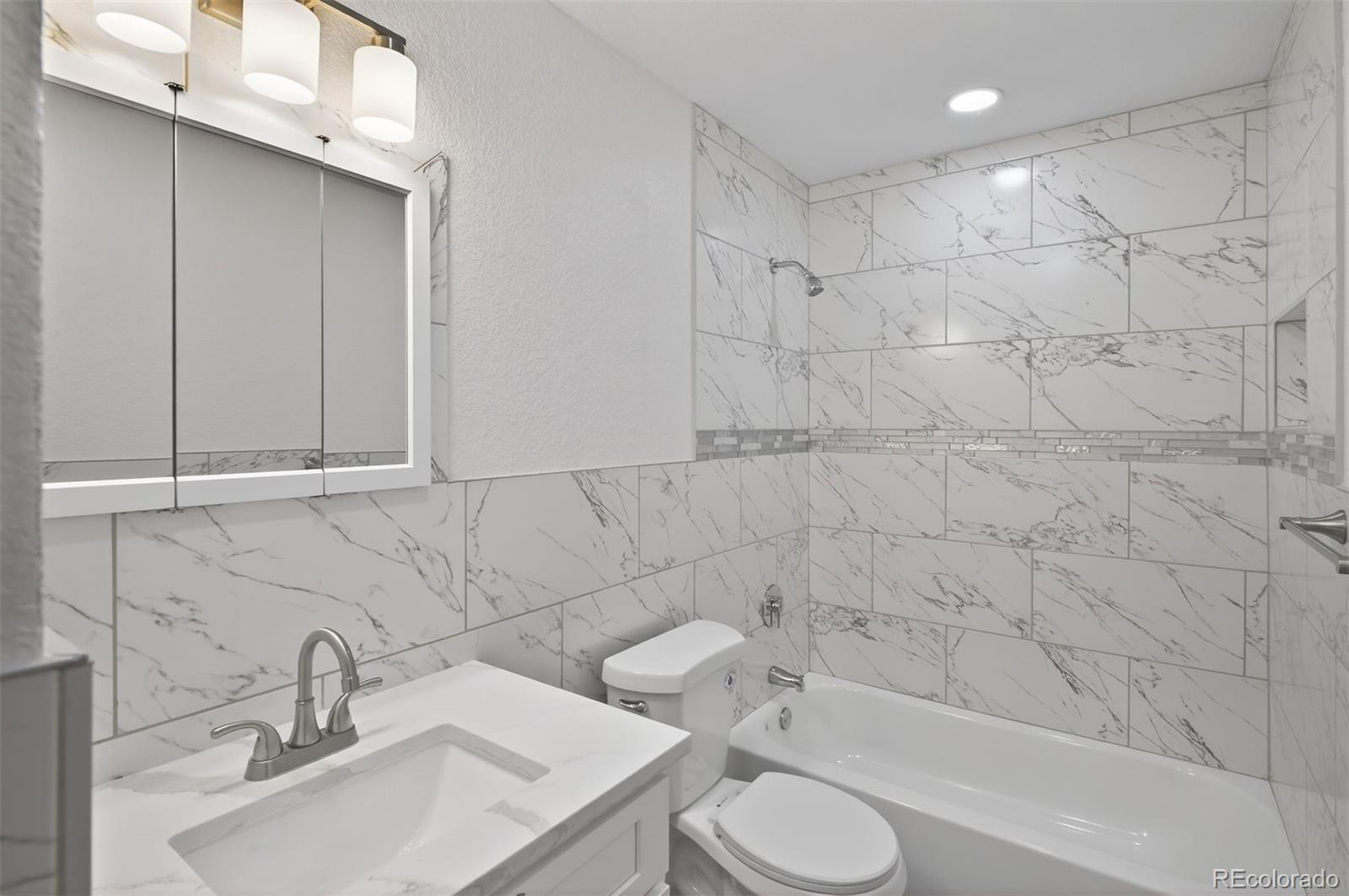 9079 Dudley Street Westminster, CO 80021 - Photo 14 of 37 a bathroom with a sink toilet and shower