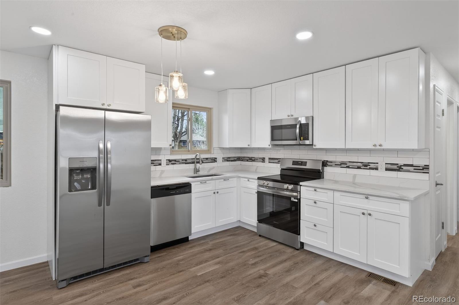 9079 Dudley Street Westminster, CO 80021 - Photo 10 of 37 a kitchen with cabinets stainless steel appliances and a counter space