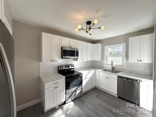 a kitchen with stainless steel appliances a stove sink microwave and cabinets