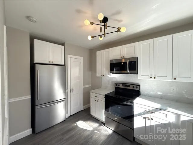 a kitchen with stainless steel appliances a refrigerator a stove a microwave and cabinets