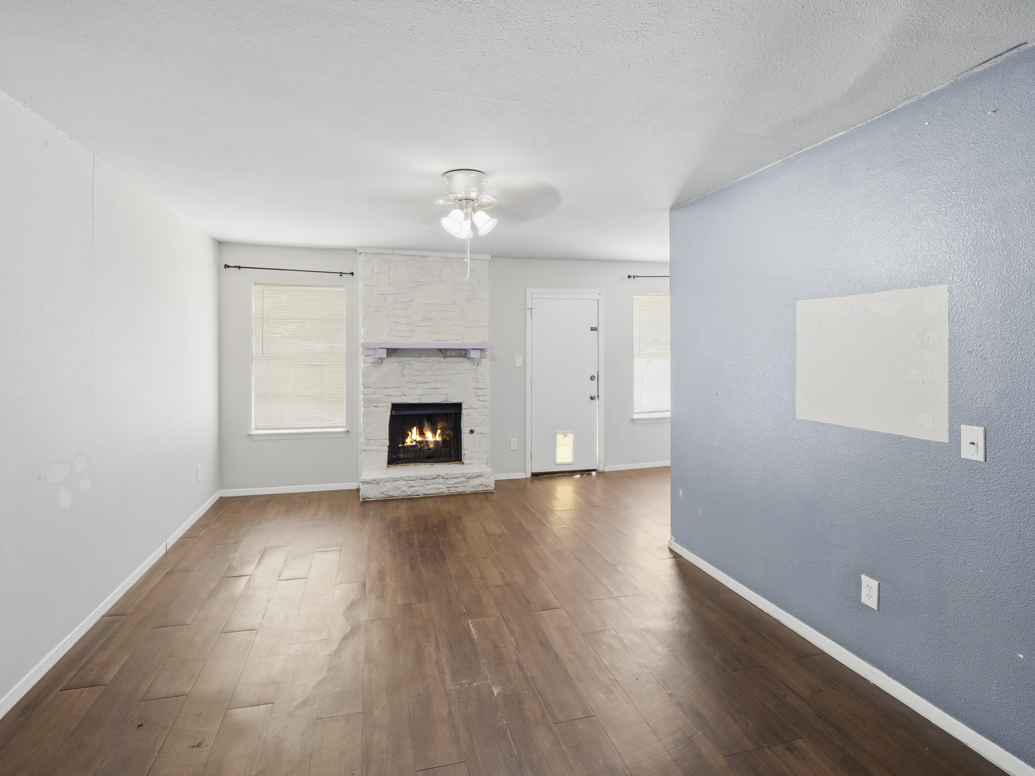 2401 Burleson Road Austin, TX 78741 - Photo 15 of 25 A cozy living space features rich wood flooring and a stone-clad fireplace, perfect for tranquil evenings.