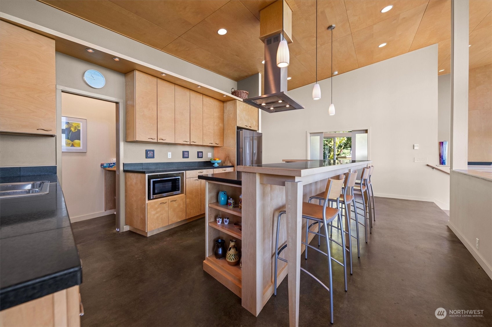 15550 Sandridge Road Long Beach, WA 98631 - Photo 12 of 36 a kitchen with stainless steel appliances kitchen island granite countertop a table chairs and a refrigerator