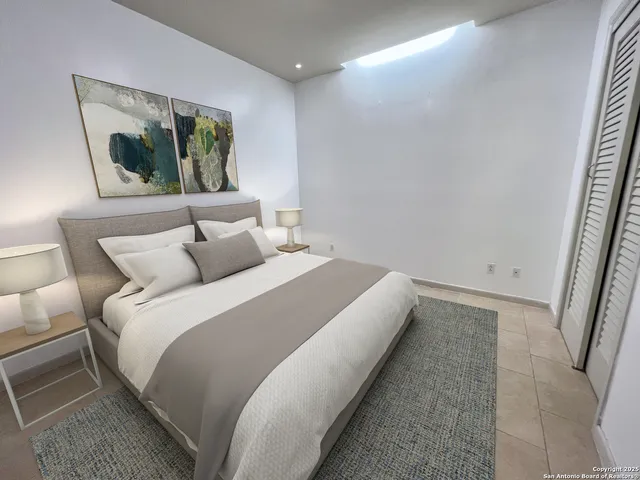 a bed room with a bed and a painting on the wall