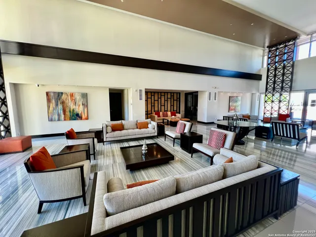 a living room with furniture kitchen view and a large window