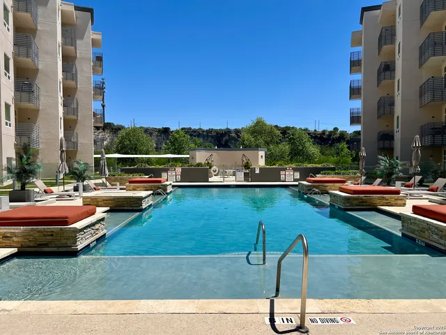 a view of swimming pool with outdoor seating and lake view