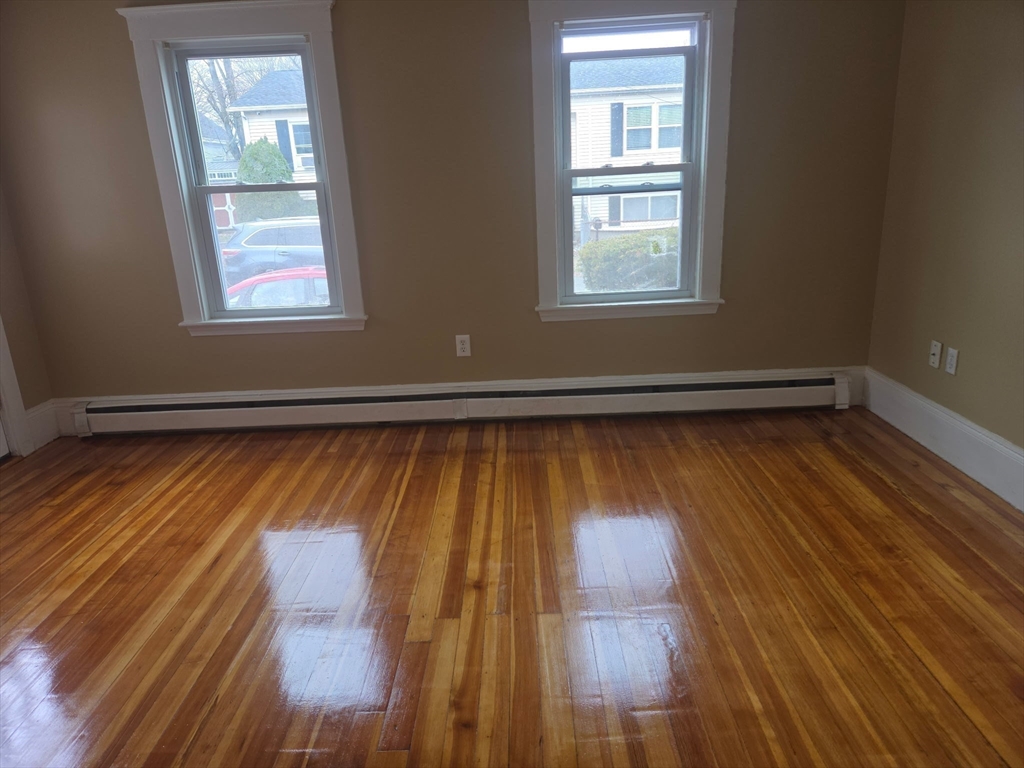 53 Groveland Street Lynn, MA 01902 - Photo 11 of 28 an empty room with wooden floor and windows