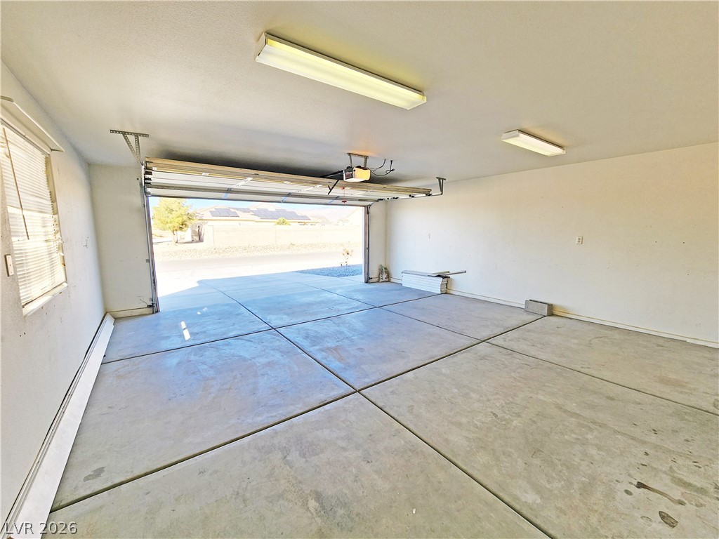 4591 Stoneham Street Pahrump, NV 89061 - Photo 38 of 42 A spacious garage features concrete flooring, bright overhead lighting, and an automatic door for effortless access.