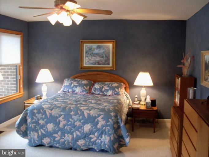 11082 Thrush Ridge Road Reston, VA 20191 - Photo 9 of 14 a bed sitting in a bedroom next to a lamp