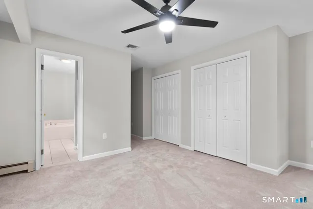 an empty room with closet and fan