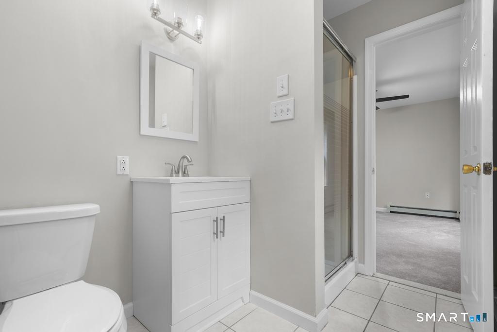 815 South Pine Creek Road Fairfield, CT 06824 - Photo 20 of 32 a bathroom with a toilet a sink and mirror