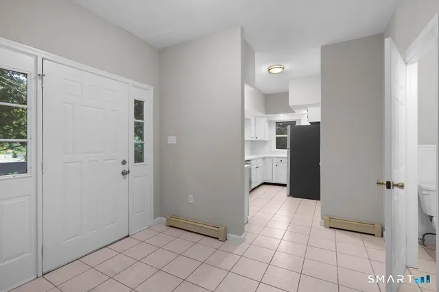 a view of a refrigerator and mirror in a room