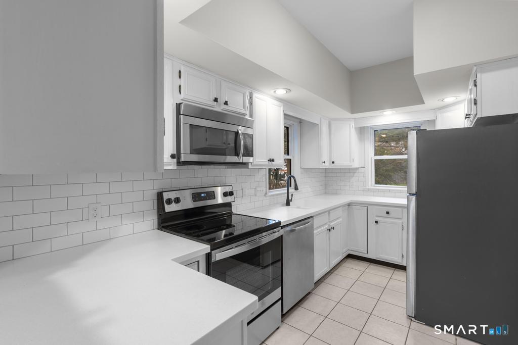 815 South Pine Creek Road Fairfield, CT 06824 - Photo 5 of 32 a kitchen with a sink stove and microwave