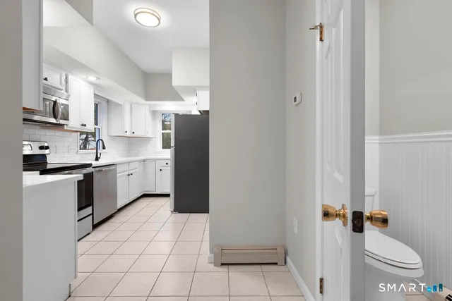 a kitchen with a sink a white cabinets and white appliances