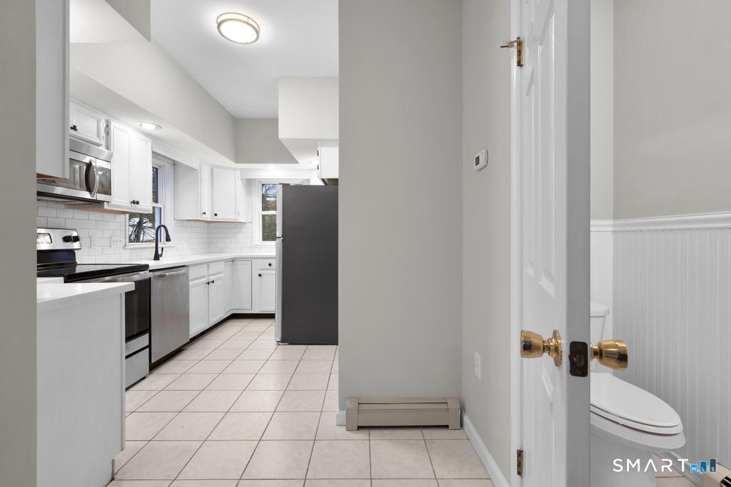 815 South Pine Creek Road Fairfield, CT 06824 - Photo 9 of 32 a kitchen with a sink a white cabinets and white appliances