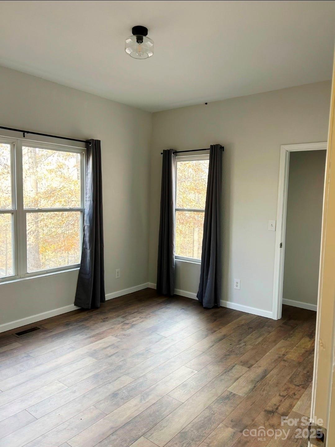 178 Levi Road Columbus, NC 28722 - Photo 27 of 36 an empty room with wooden floor and windows
